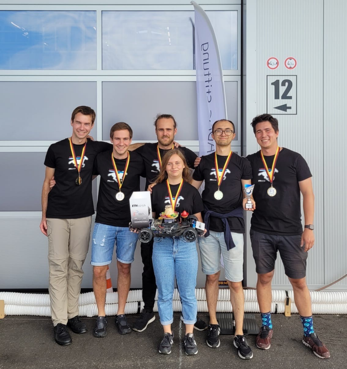 Winning team with gold medals and racing car