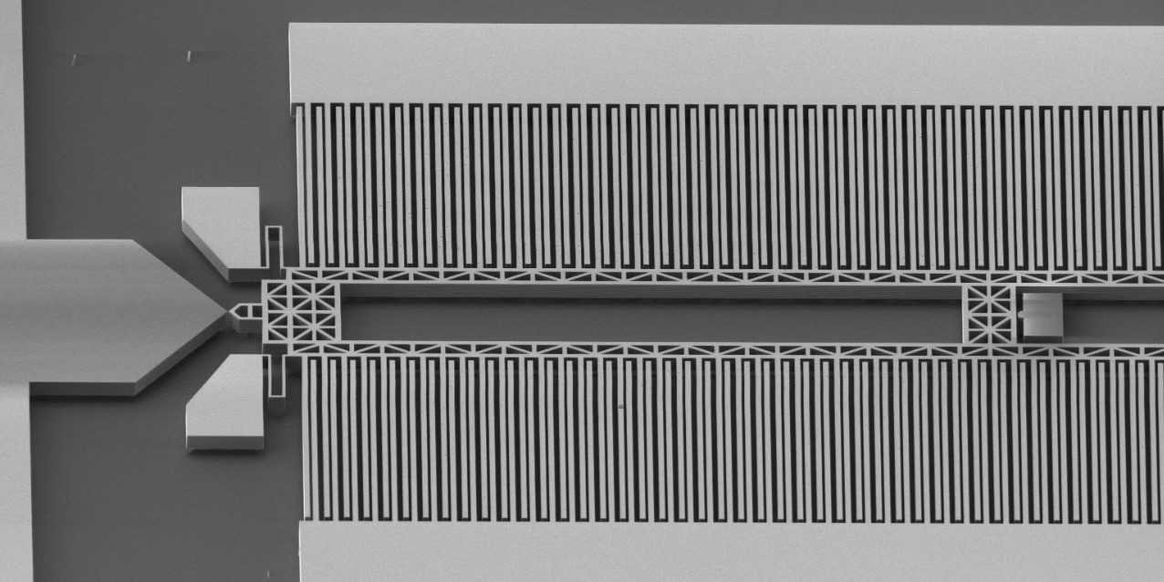 The system consists of interdigitated combs that move when an electrical voltage is applied between them. Various nanomaterials can be transferred onto the two tips on the left and strained in a controllable manner.